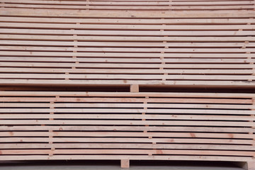 Warehouse or factory for sawing boards on sawmill indoors. Wood timber stack of wooden blanks construction material. Logging Industry.