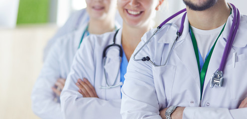 Happy medical team comprising male and female doctors smiling broadly and giving a thumbs up of success and hope