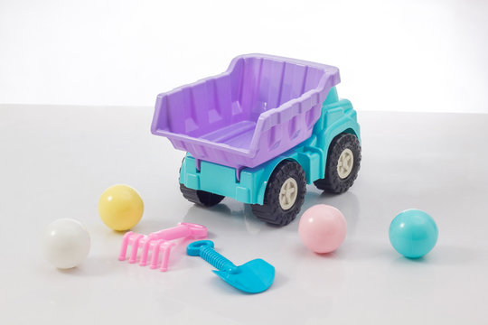 colorful toy truck and beach toy isolated on white