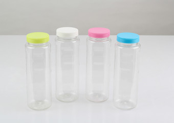 plastic water bottles with colorful lids isolated on white