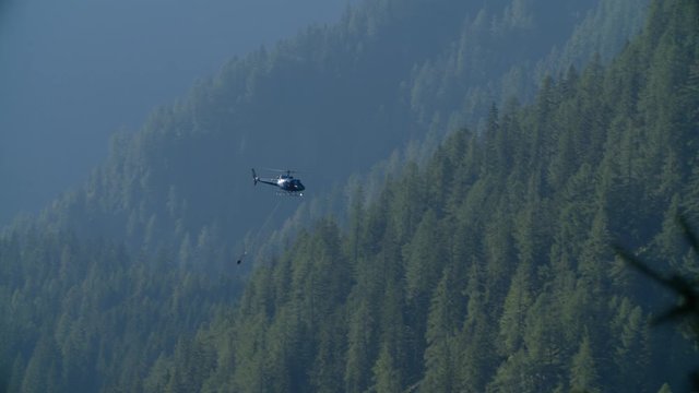 Helicopter AS350 landing with empty hook, aerial work in dolomites mountains, high quality 4k prores telephoto lens