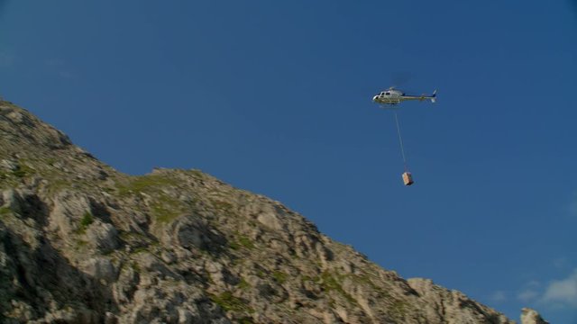 Helicopter AS350 flight carrying cargo on hook