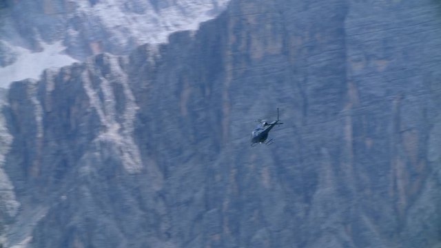 Helicopter AS350 fast flyby and flight towards rocky mountains, high quality prores 4k