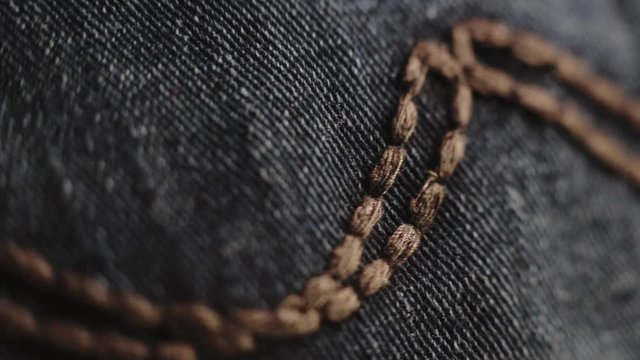 Brown stitches on blue denim - Macro shot