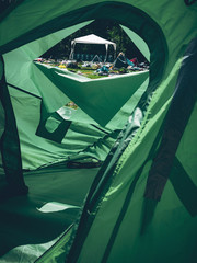 Look out of a green tent on a music festival with waste all over the place
