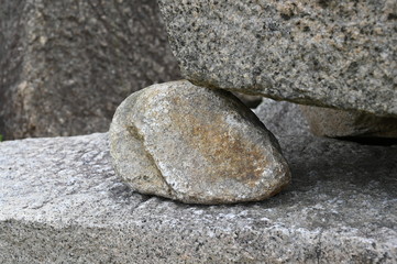 A small stone between two large stones. A little stone supporting other stones. 