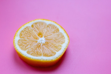 Flat lay composition with yellow lemons and space for text on color pink background.