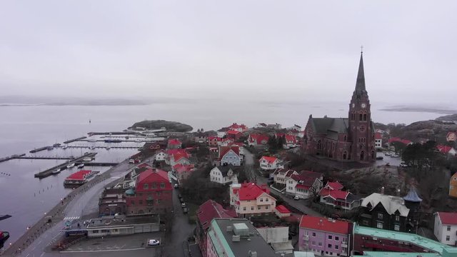 Flying Over the Peaceful City in Lysekil, Sweden With Beautiful Scenery of Exotic Houses, church and Calm ocean - Aerial Shot