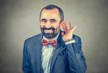 Man with his hand to his ear trying to listen