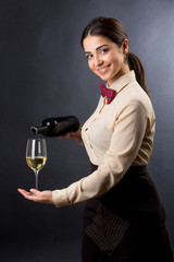 cameriera serve il vino in un calice con grande cura