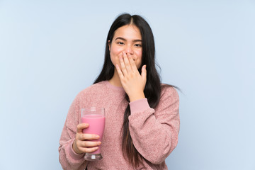 Young teenager Asian girl with strawberry milkshake with surprise facial expression