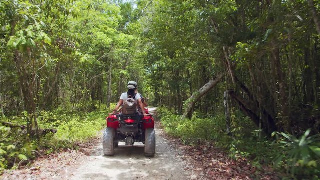 Driving Quad Bikes through Tropical Forest Trail.
Slow Motion Back Shot of Friends Enjoying ATV Bike Tour through the Woods
