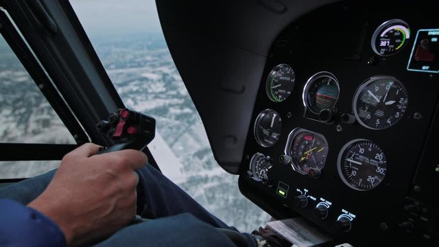 View of helicopter cockpit, instrument panel and pilots hand on the stick during the flight in winter, high quality 4k prores