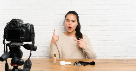 Young blogger Asian girl recording a video tutorial with surprise facial expression