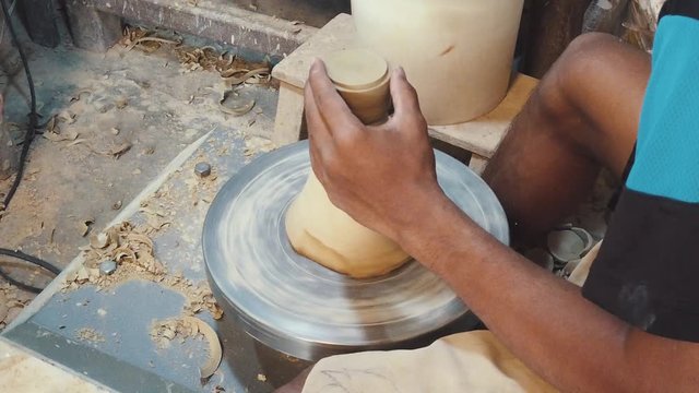 Close Slow Motion Shot of a Craftsman Creating a Vase on a Pottery Wheel in the Studio