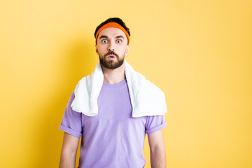 shocked bearded sportsman looking at camera on yellow