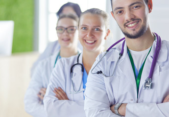 Happy medical team comprising male and female doctors smiling broadly and giving a thumbs up of success and hope