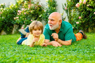 Naklejka na ściany i meble Portrait of happy senior man father smiling and happy cute son. Happy senior man Grandfather with cute little boy grandson playing and looking at camera.