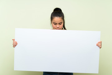 Young teenager Asian girl over isolated green background holding an empty white placard for insert a concept
