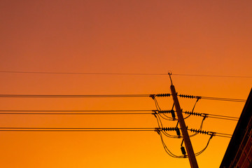 Fototapeta na wymiar Cable wire and electricity post with warm sky in the evening