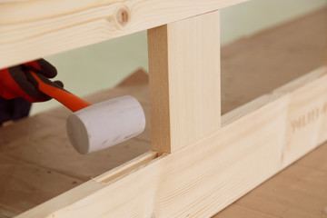 Assembling a wooden frame for a frame house. Hammer a frame element