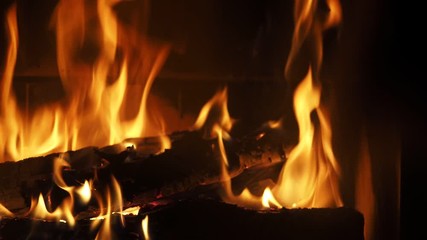 Wood Burning in a Fireplace. Warm cozy fire in a Fireplace. Home cosiness. Flames of fire on black background 4k Footage