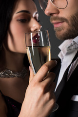 selective focus of beautiful couple holding glass of champagne on valentines day, isolated on grey