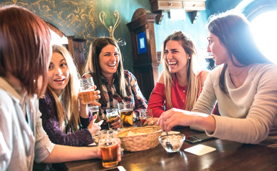 Happy women drinking beer at brewery restaurant - Female friendship concept with young girlfriends...