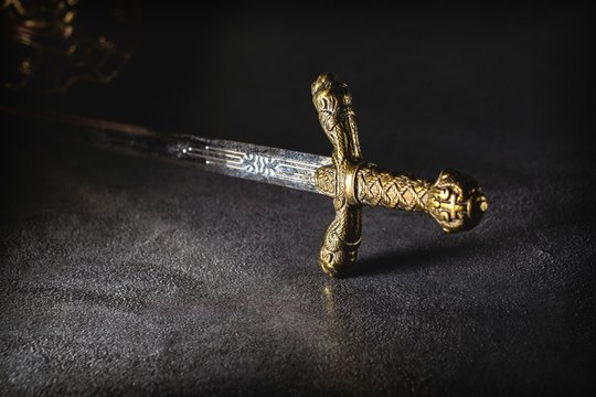 Knight's sword on a gray granite background