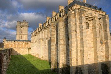 Fototapeta na wymiar Donjon with west side of the Chateau de Vincennes in a low winter sun, seen from the street