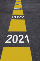 Number of 2021 to 2025 on asphalt road surface with marking lines, happy new year concept