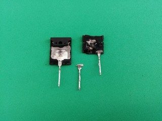 parts of an old broken bipolar transistor on a green background