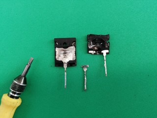 broken bipolar transistor with a screwdriver on a green background