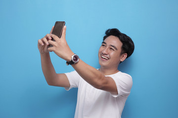 Happy young man taking selfie photograph by phone