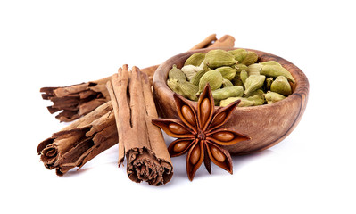 Cinnamon with cardamom and anise  in wooden bowl  on white background.