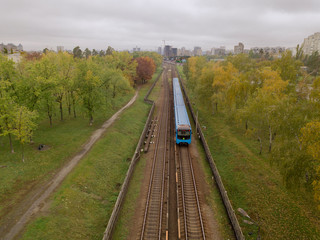 Fototapeta na wymiar Aerial drone view. The train of the Kiev subway passes through the park.