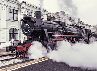 Obraz na płótnie Canvas Departure of the retro steam train at evening time.
