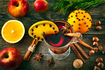 Christmas hot mulled wine with spices, cinnamon sticks, anise, orange, nuts and apples on a old...