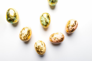 Natural Golden Speckled Easter Eggs of pastel colors on white background. Happy Easter card concept, minimalistic design, copy space