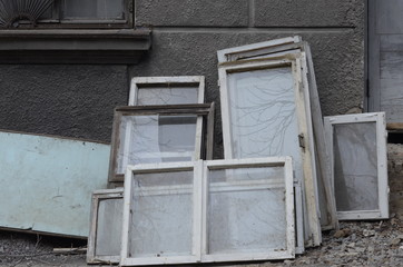 Heap of construction debris from old wooden window frames with glass. Construction waste from renovation house. Recycling of end-of-life building glass. Broken materials after upgrading windows 