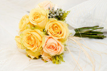 Ramo de bonitas rosas amarillas sobre el vestido de una novia