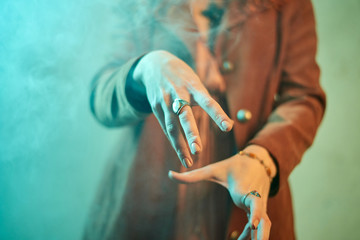 Witch making a spell with hand full of jewelry