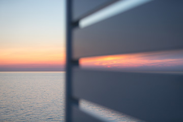 Fototapeta premium Blick auf den Sonnenuntergang am Horizont vom Deck eines Schiffes aus