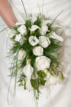 Ramo  de flores de alcatraz y rosas blancas en las manos de una novia
