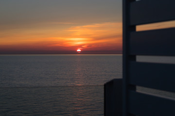 Blick auf den Sonnenuntergang am Horizont vom Deck eines Schiffes aus