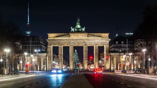 Illuminated Brandenburg Gate and Berlin TV tower at night. Car trafic, time lapse video.