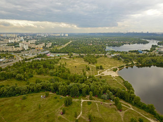 Fototapeta na wymiar Aeiral drone view. Green banks of the Dnieper River near Kiev in cloudy weather on the outskirts of the city.