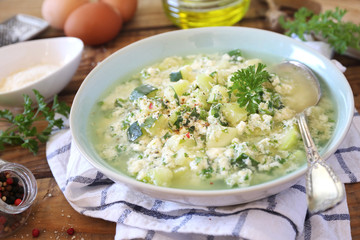 Italian cuisine. Stracciatella zucchini soup: parsley, eggs and parmesan cheese