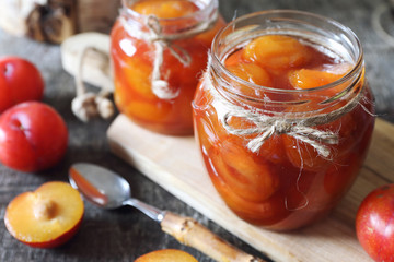 Autumn sweet. Homemade red plums jam in two jars and fruits