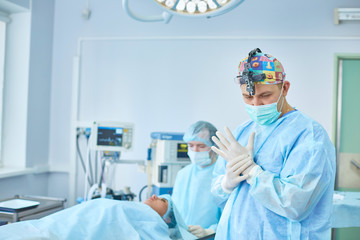 Several doctors surrounding patient on operation table during their work. Team surgeons at work in operating room